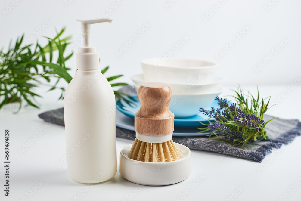 eco-friendly dishwashing brushes with organic bristles and wooden handle next to dishwashing detergent on the kitchen table. The concept of minimum consumption,