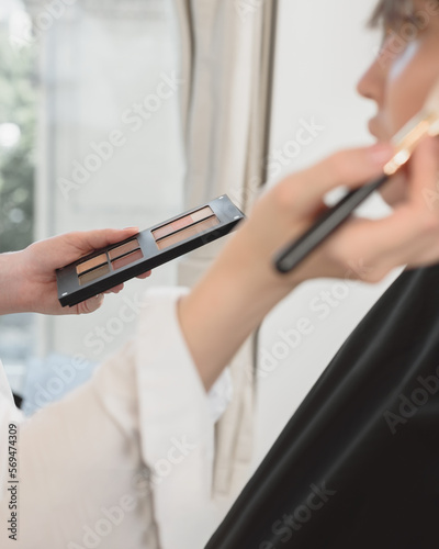 Make-up artist in process of doing makeup to her female client
