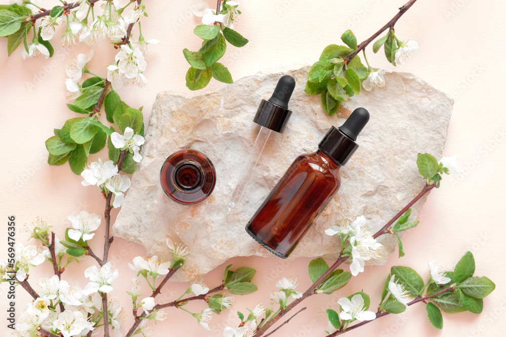 Natural oil cosmetics. Dropper glass Bottle Mock-Up. Oily cosmetic pipette on a stone Podium on pink background. White flowers, soft shadow. Scene, Showcase, display. Minimal design. Top view Flat lay Natural oil cosmetics. Dropper glass Bottle Mock-Up. Oily cosmetic pipette on a stone Podium on pink background. White flowers, soft shadow. Scene, Showcase, display. Minimal design. Top view Flat lay
