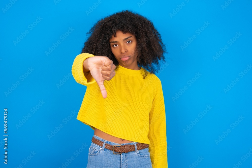 MODEL looking unhappy and angry showing rejection and negative with thumbs down gesture. Bad expression. MODEL looking unhappy and angry showing rejection and negative with thumbs down gesture. Bad expression.