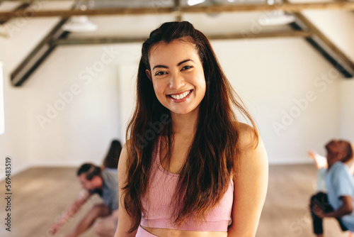 Happy yoga instructor smiling at the camera in a fitness studio photo