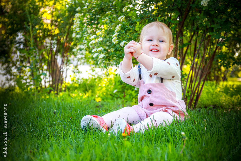 little child playing in the park. A girl child rejoices on the grass. A little girl on the green grass. Cute toddler on green grass. little child playing in the park. A girl child rejoices on the grass. A little girl on the green grass. Cute toddler on green grass.
