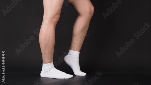 Asian Male legs wear white sock is isolated on black background