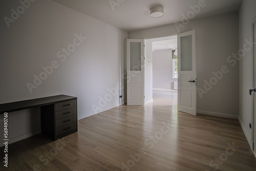 Classical empty room interior. The rooms have wooden floors and gray walls  decorate with white moulding there are white window looking out to the nature view.