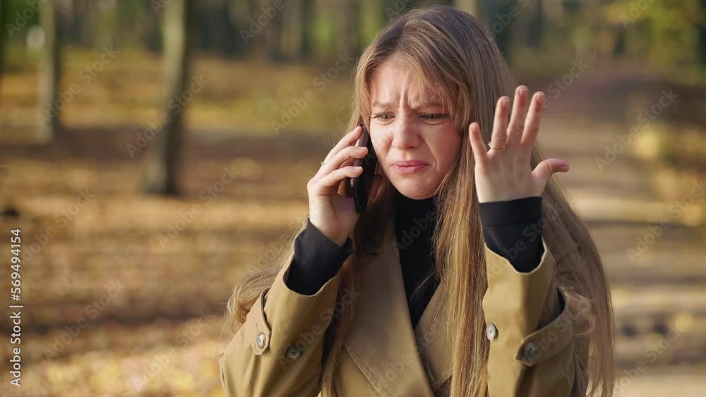 Side view of young, stylish woman wearing fashionable clothes, talking on phone. Attractive female crying, quarreling, raising hands, angry, irritated. Concept of modern living. Side view of young, stylish woman wearing fashionable clothes, talking on phone. Attractive female crying, quarreling, raising hands, angry, irritated. Concept of modern living.