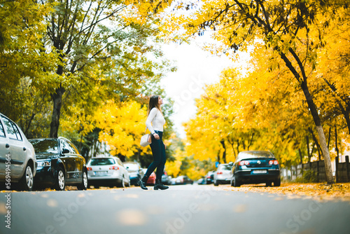 Photography Girl Walking in the Middle of Street in Fall Season