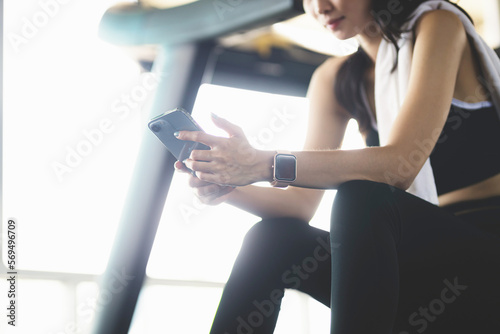 Asia woman active smartphone in gym exercising