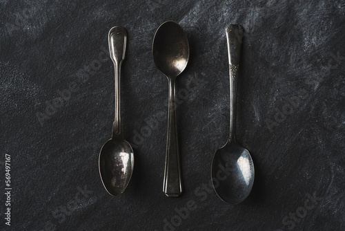 Vintage spoons on rustic black background