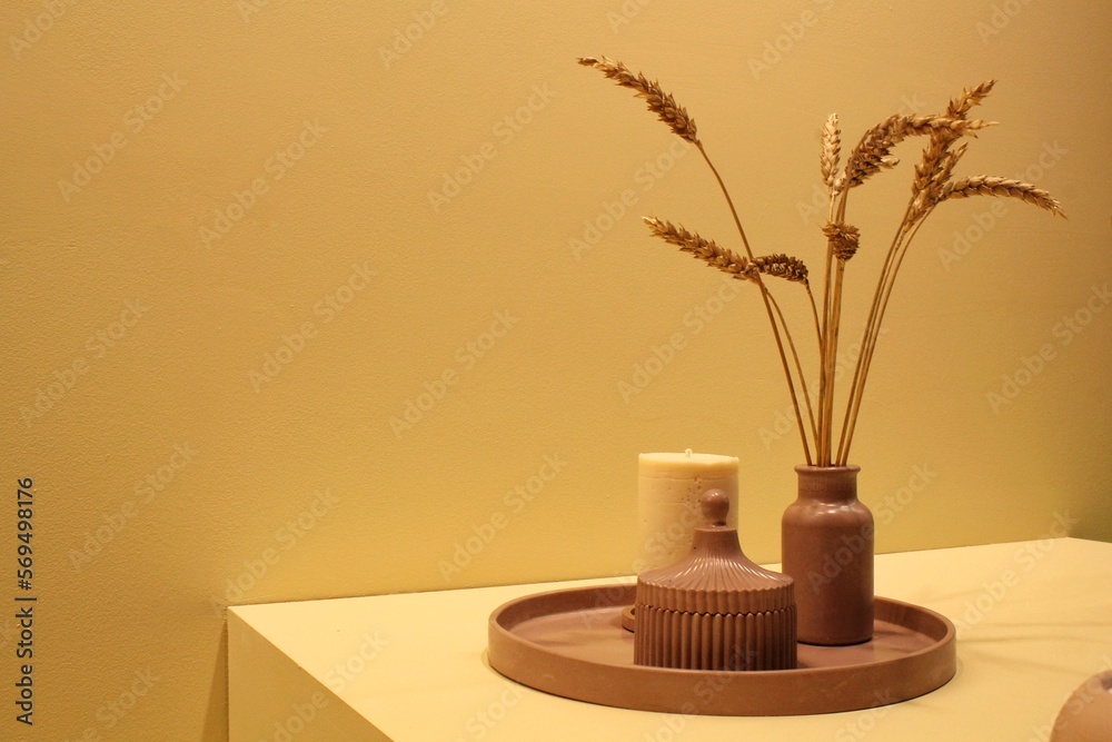 Aroma candle and dry wheat in ceramic vase on table. Zen, relax, wellness concept. Decoration organic equipment in spa salon. Natural composition for meditation. Healthy beauty lifestyle. Aroma candle and dry wheat in ceramic vase on table. Zen, relax, wellness concept. Decoration organic equipment in spa salon. Natural composition for meditation. Healthy beauty lifestyle.