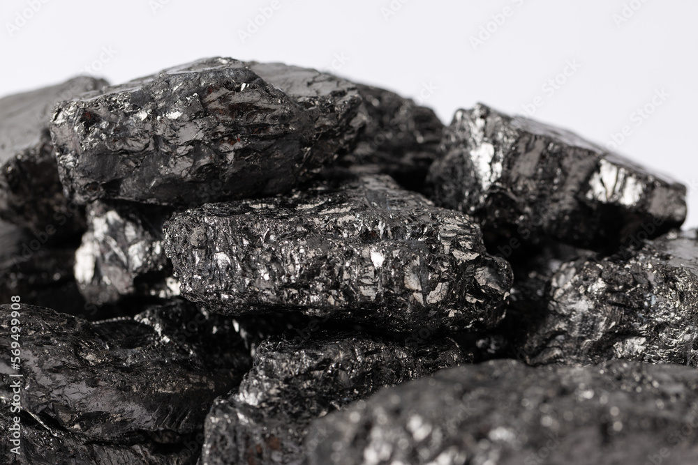 Fototapeta premium Heap of natural black fossil coal on a white isolated background.