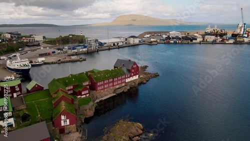 4K aerial view of Tórshavn harbour and Tinganes historic old town, with typical turf-roofed red houses and sail boats in the port - Faroe Islands Capital - Fær Øer photo