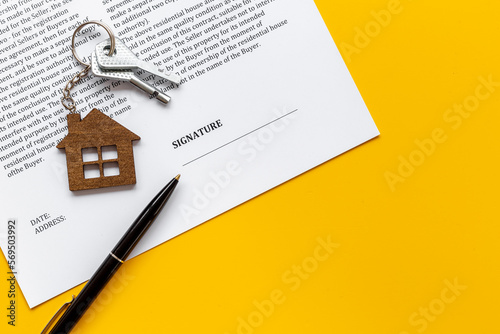 Signing a house purchase agreement concept with house shaped keychain