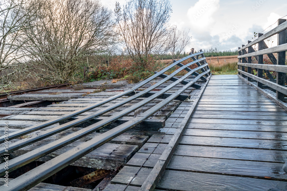 Fototapeta premium An old, rotten wooden bridge over the Owenea river by Ardara in County Donegal - Ireland