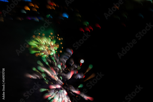 Abstract photo of firework flower. Salute without focus. Blurry photo of firework. A beautiful flicker of green bokeh.