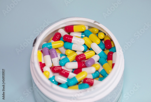 Pills spilling out of pill bottle and isolated on blue. Top view with copy space. Medicine concept.