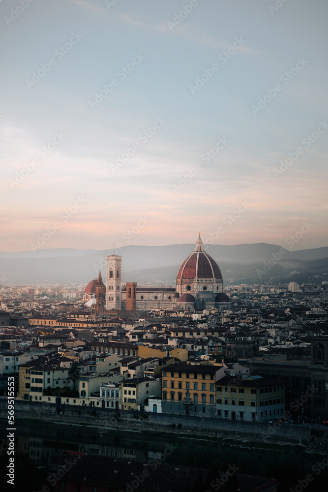 Florence city panorama from Michelangelo square at sunset. Vertical shot, Blue and red sky, misty, foggy background. Florence, Tuscany, Italy. Cattedrale di Santa Maria del Fiore.