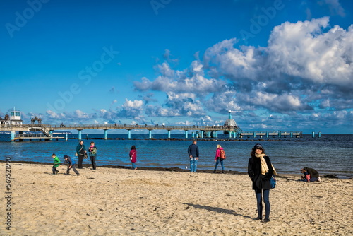 sellin, deutschland - frau am strand vor seebrücke im herbst