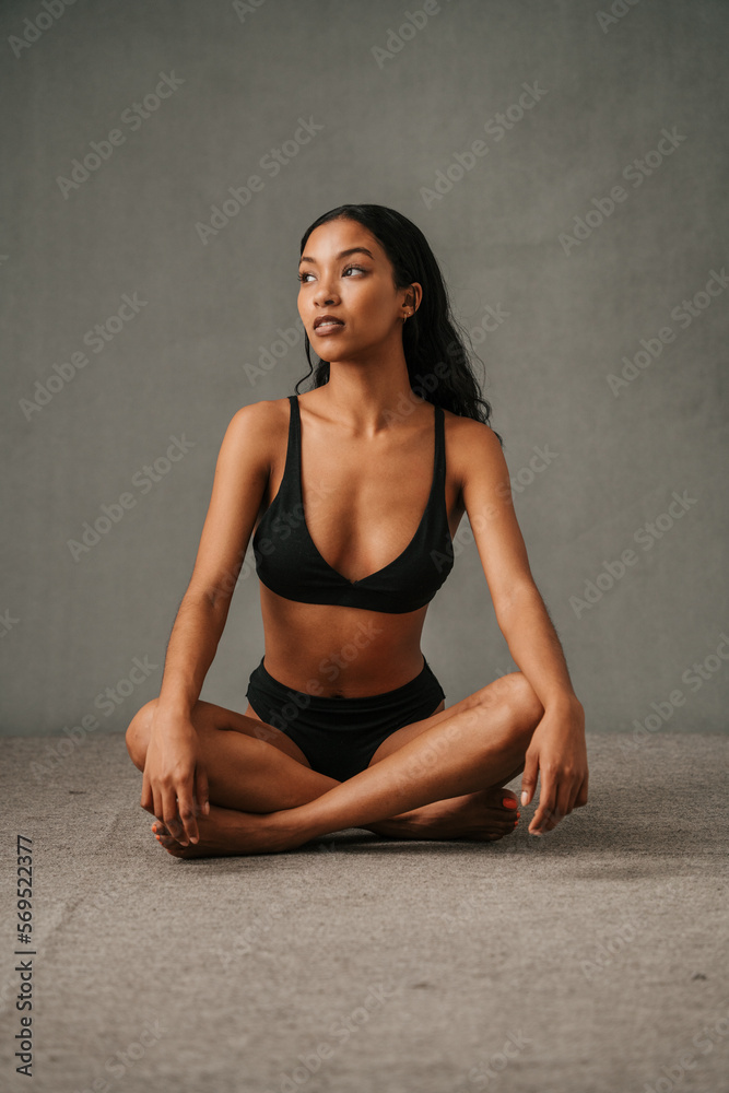 Serious Multiethnic female posing in the studio sitting on the floor