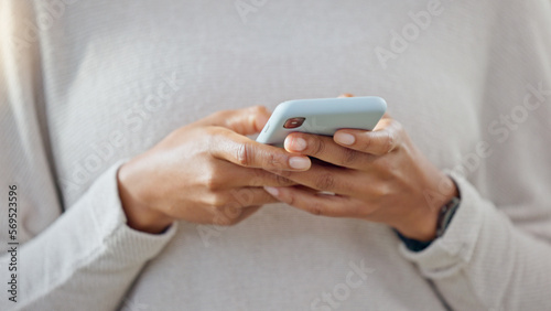 Person holding a phone while texting on social media. One trendy woman writing a quick and convenient text message on an instant chat app. Closeup of a girl browsing content online or on the internet photo