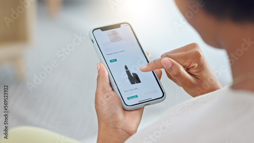 Shopping online and scrolling through makeup products to find a sale or discount. Hands of a woman browsing cosmetics on her phone from above. Enjoying the convenience and ease of purchasing apps