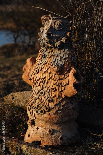 Sculpture of a fantastic ancient pagan god totem idol carved from a tree in the forest. photo