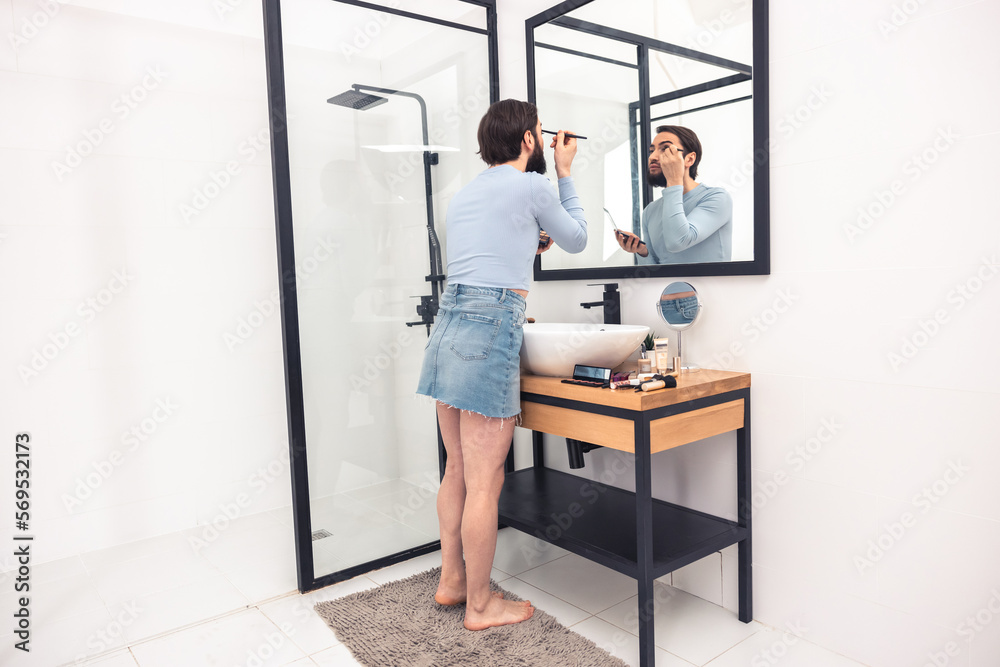 Guy applying the eyeshadows to his upper eyelid
