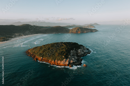 Die Insel Ilha do Batuta vor dem Strand Praia do Luz und Praia da Rosa. Insel aus der Luft gefilmt. Kleine Insel sieht wie ein Herz aus. Blaues Meer und Wellen Drohne 1 photo