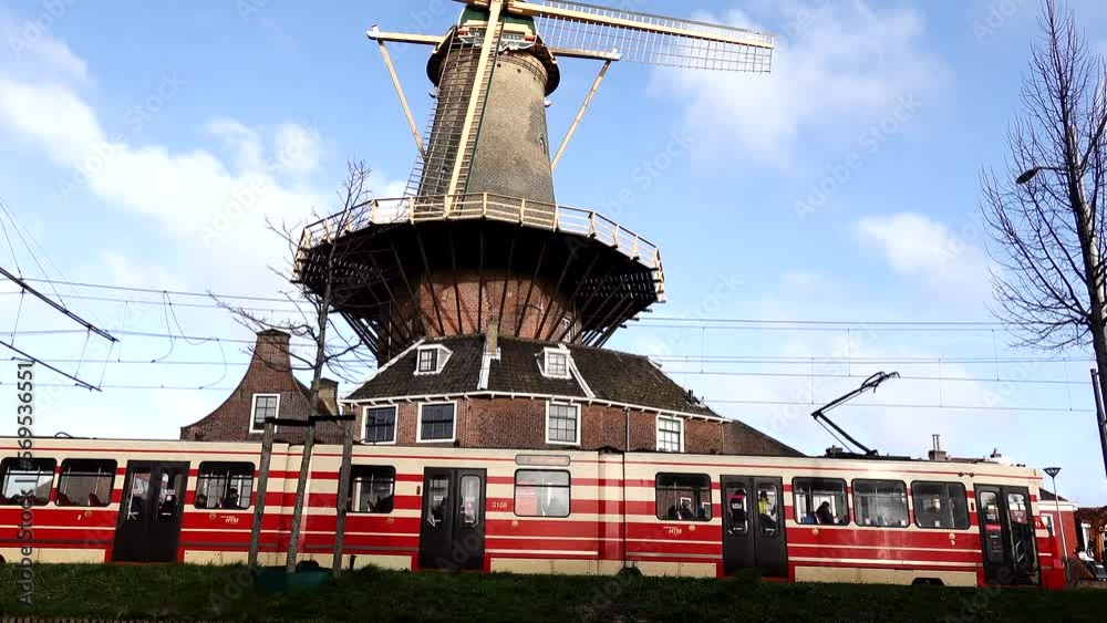 Delft, Netherlands A tram rides by an old windmill in the center of