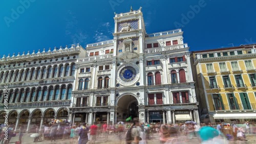 St Mark's Clock tower timelapse hyperlapse on Piazza San Marco, facade, Venice, Italy. Tourists on the square. On the facade of the tower is the astronomical clock, Lion of Saint Mark photo
