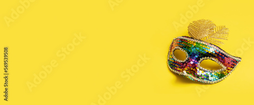 Festive face mask for carnival celebration or masquerade on colored background