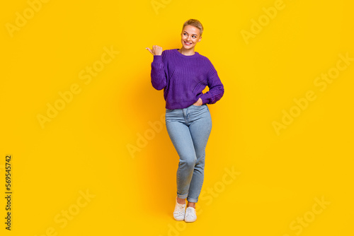 Full size portrait of positive charming girl look direct thumb finger empty space isolated on yellow color background