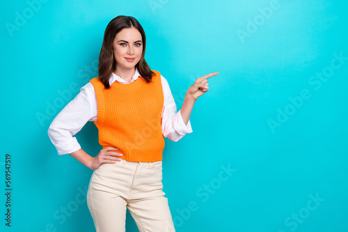 Photo of satisfied optimistic woman with bob hairstyle dressed orange waistcoat indicating empty space isolated on teal color background