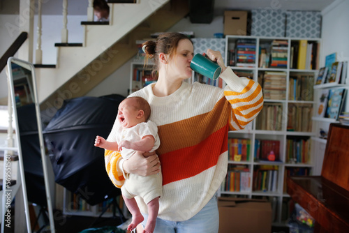 Maternal burnout and depression, difficulties of motherhood. Tired plus size mom with crying baby in hand.