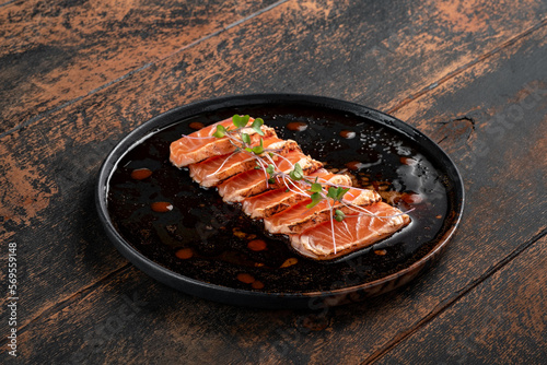 Fillet of fresh smoked salmon sliced on a plate with soy sauce. Asian dish sashimi from raw salmon