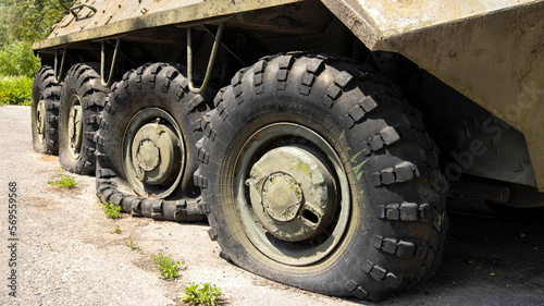Wheels of armored personnel carriers pierced by bullets during a military battle. Military conflict and weapons. Equipment damage.