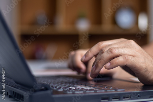 Male hands typing on laptop keyboard and surfing internet on desk, business concept and technology, internet network communication