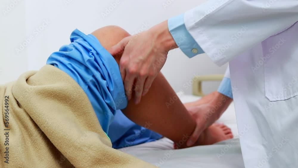 An Asian doctor checks the knees of an obese patient lying on a nursing bed. The concept of osteoarthritis in obese people. Hospital medical services An Asian doctor checks the knees of an obese patient lying on a nursing bed. The concept of osteoarthritis in obese people. Hospital medical services