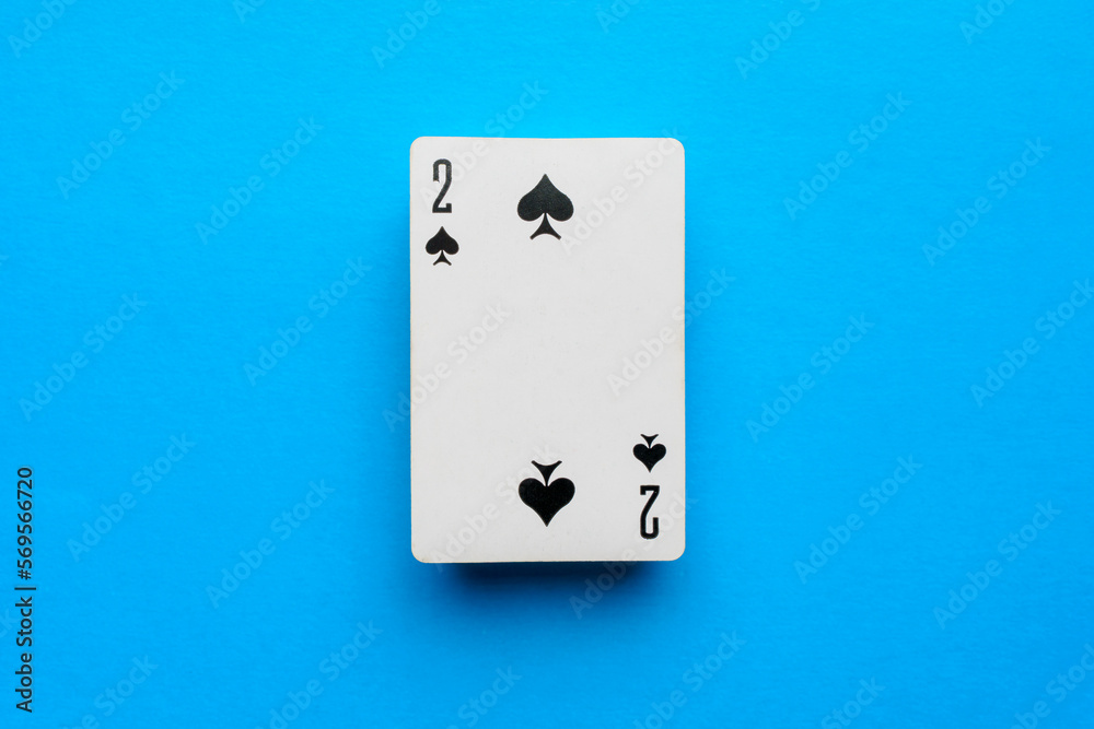 Playing card deuce of spades on a blue background