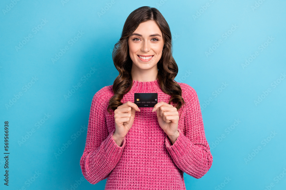 Photo of adorable positive lady hand showing plastic bank card isolated on blue color background Photo of adorable positive lady hand showing plastic bank card isolated on blue color background