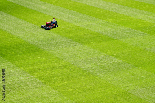 Mowing the grass on the football field. Football field maintenance.