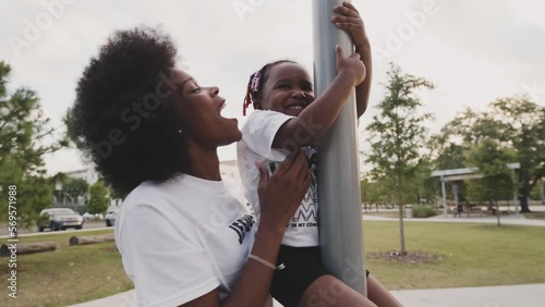 Black Stock Footage of happy, young, and smiling Black family playing in a nature park on a sunny day with Black mother, Black father, and Black children