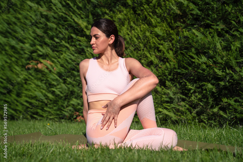 A girl is engaged in yoga on the street, in a pink tracksuit does various exercises and yoga poses A girl is engaged in yoga on the street, in a pink tracksuit does various exercises and yoga poses