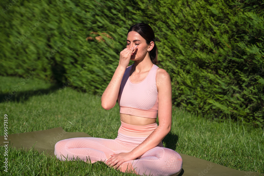A girl is engaged in yoga on the street, in a pink tracksuit does various exercises and yoga poses A girl is engaged in yoga on the street, in a pink tracksuit does various exercises and yoga poses