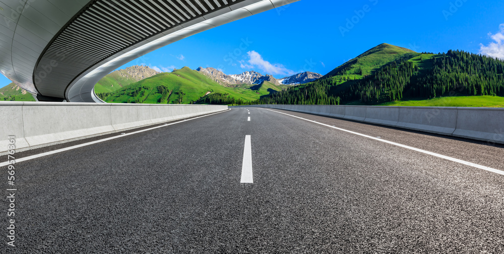 Fototapeta premium Asphalt road and bridge with green mountain background in Xinjiang, China.