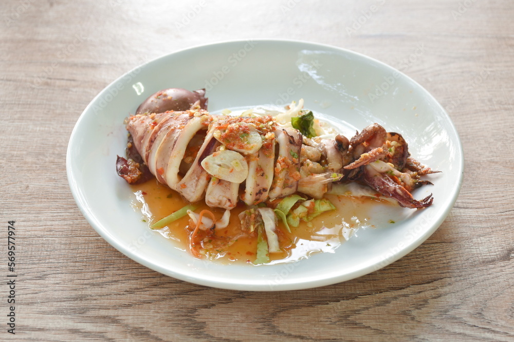 grilled squid dressing spicy and sour lemon sauce isolated on plate grilled squid dressing spicy and sour lemon sauce isolated on plate