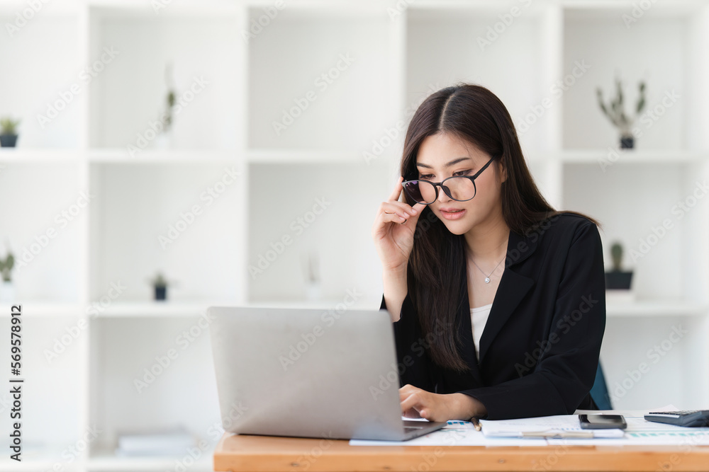 Asian Business woman working at home office and analyze financial report document. Accounting and Finance concept Asian Business woman working at home office and analyze financial report document. Accounting and Finance concept