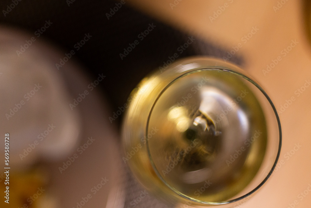 White wine served on a transparent drinking glass on a wooden table background