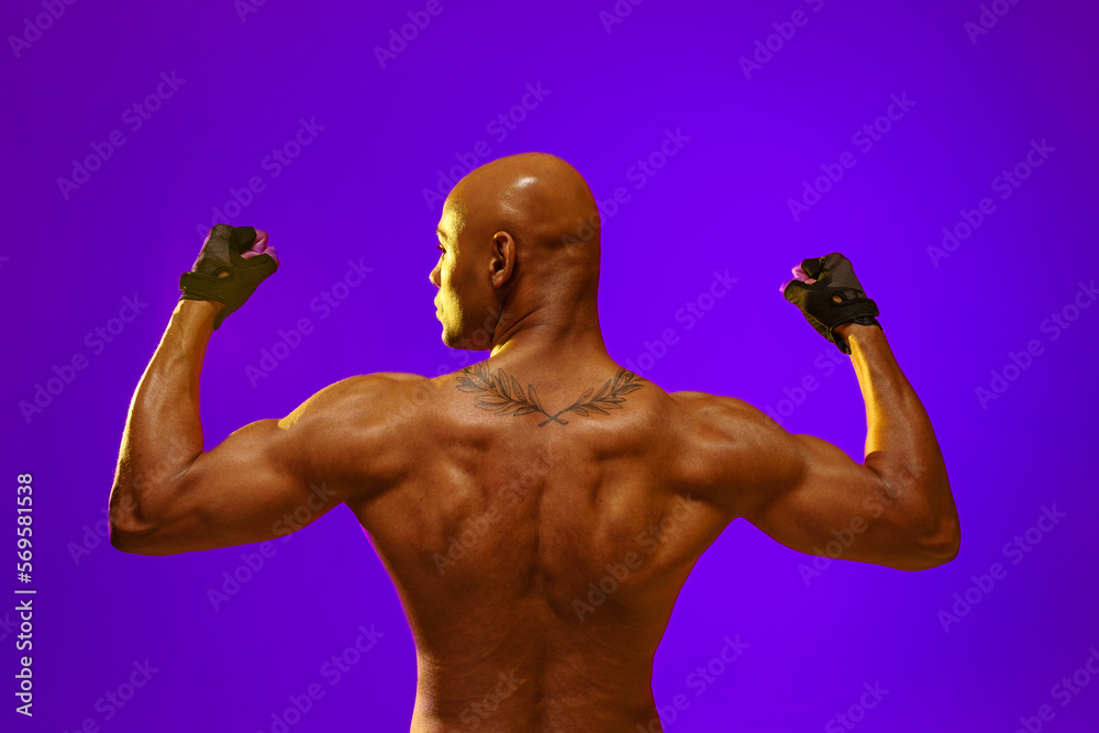 Back view of naked torso of muscular man on studio background. Strength and motivation Back view of naked torso of muscular man on studio background. Strength and motivation