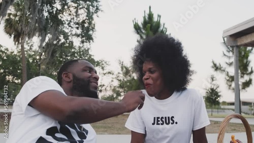 Black Stock Footage of happy, young, and smiling Black family playing in a nature park on a sunny day with Black mother, Black father, and Black children