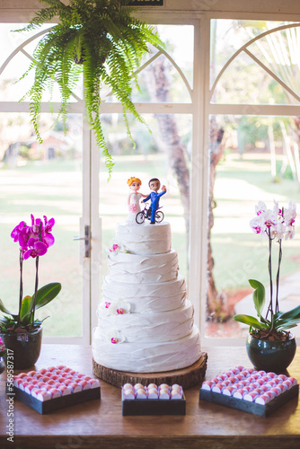  fake wedding cake with the bride and groom on the top and the groom on a bicycle